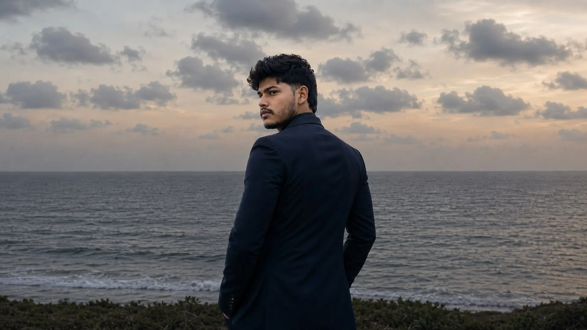 Krishna Sahani, founder and entrepreneur, standing by the ocean at sunset